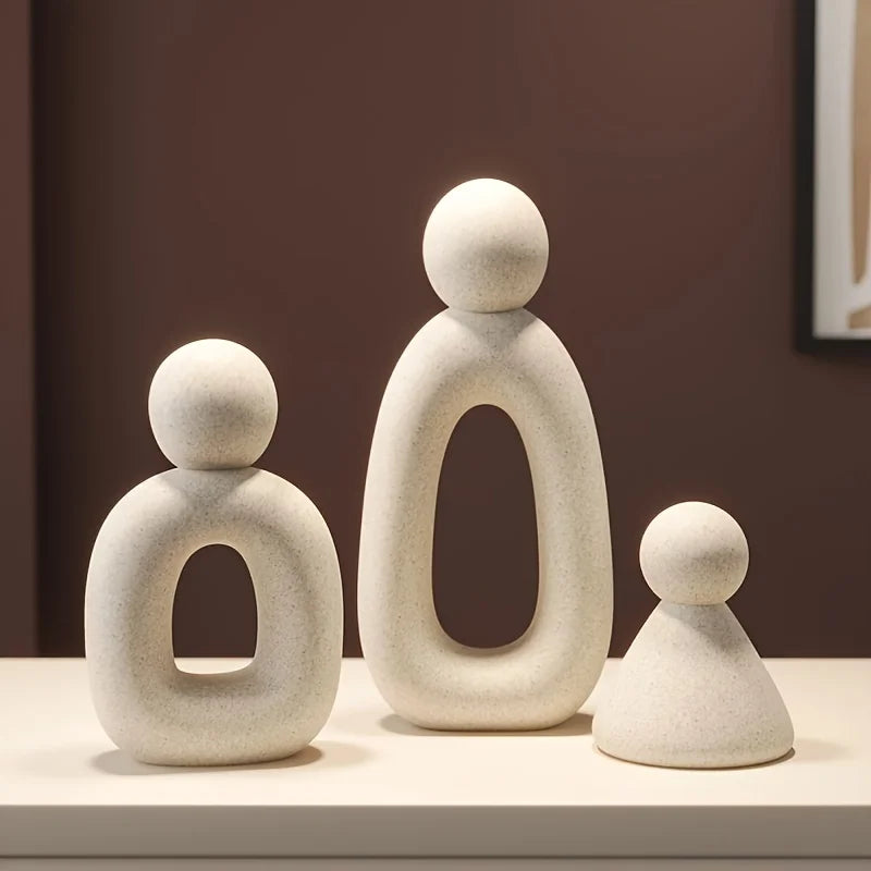 Three white abstract sculptures on a surface with a dark brown background