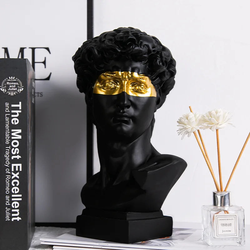 David bust with gold mask on a surface with a book and vase in the background