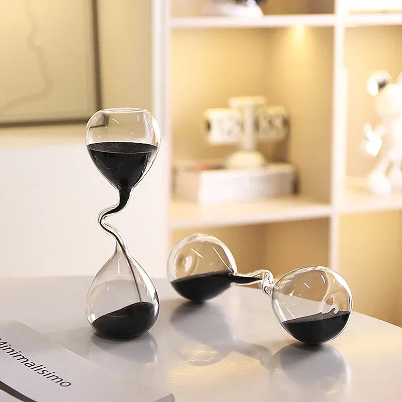 Two hourglass-like sand timers on a surface with a blurred background